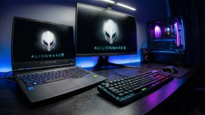Alienware 遊戲筆記型電腦和顯示器，配備 RGB 鍵盤和發光 PC 機箱，置於深色桌上。 — Alienware GIF 壁紙