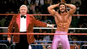 兩位摔角手在擂台上，一位身穿閃亮外套，另一位身穿粉紅色波點緊身褲。