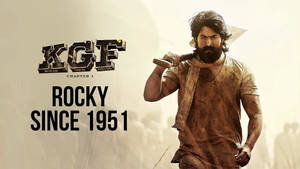《KGF Chapter 1》中洛奇手持錘子並帶有文字的電影海報。