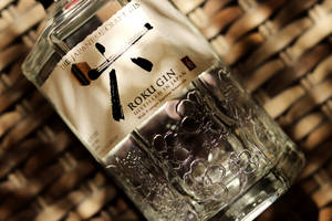 Roku Gin 酒瓶，在編織竹面上有花卉圖案。