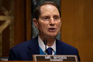 參議員Ron Wyden穿著藍色西裝和領帶在正式聽證會上演講。 — 政治 壁紙