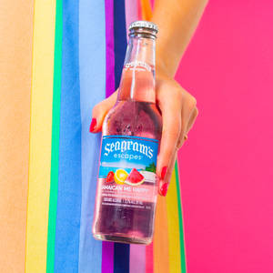 手拿著 Seagram's Escapes 瓶子，背景為彩虹條紋。 — 電腦 壁紙