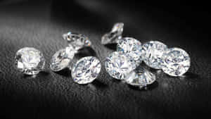 在黑色紋理表面上一簇閃閃發光的鑽石。