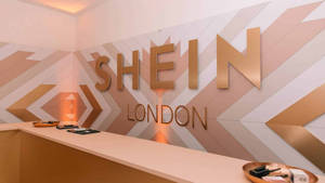 Shein London 商店接待處，金色字體和幾何牆壁設計。