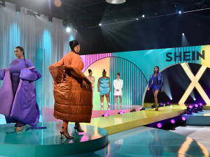 模特兒在 SHEIN X 活動中穿著大膽時尚走過色彩繽紛的跑道。