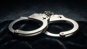 深色天鵝絨布料上的閃亮金屬手銬。