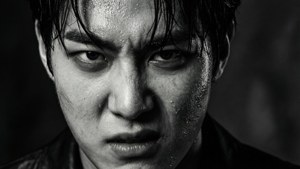 一名頭髮濕透、臉上流汗的男子，在黑白畫面中專注地向前凝視。