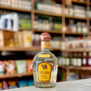 Siete Leguas龍舌蘭酒瓶放在大理石吧檯上，後面有酒架。