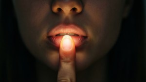 人將手指放在嘴唇上做出安靜的手勢。