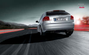 銀色 Audi S3 在夕陽下的山路上疾馳，帶有動態模糊效果。 — Steam Deck 壁紙