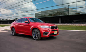 陽光明媚嘅日子，紅色BMW X6 M停喺玻璃建築前面。 — Steam Deck 壁紙