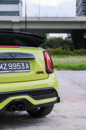 青檸綠色MINI Cooper S開篷車停放在城市高架橋下。 — iPhone Duo 壁紙