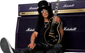 Slash 在紫色 Marshall 擴音器前手持黑色電結他。