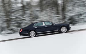 黑色賓利 Mulsanne 在冬季森林的雪路上快速行駛。 — 1280x800 壁紙