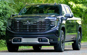 黑色GMC Sierra Denali皮卡車停泊在森林中的碎石路上。 — Steam Deck OLED 壁紙
