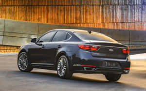 日落時分，黑色Kia Cadenza房車停泊在金色城市天橋下。 — MacBook Pro 13 壁紙