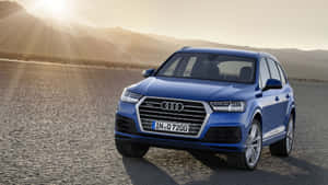 藍色奧迪Q7 SUV停泊在日落時分的沙漠公路上，背景有山脈。 — Audi R8 GIF 壁紙