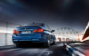 藍色BMW M5在黃昏時分於賽道上飛馳，帶有動態模糊。 — Steam Deck OLED 壁紙