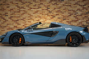 藍色McLaren Speedtail跑車，橙色制動器，磚牆。 — Surface Laptop 壁紙