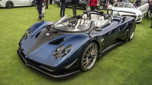 車展綠色地毯上的藍色帕加尼 Huayra 跑車與人群。 — 簡約藍色美學 壁紙