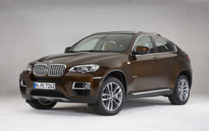 棕色BMW X6 SUV，銀色輪圈和鍍鉻細節，在攝影棚環境中。 — Steam Deck 壁紙