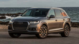 灰色奧迪Q7 SUV停泊在海洋附近，海浪拍打岩石海岸。 — Audi R8 GIF 壁紙