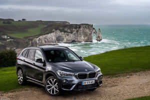 灰色BMW SUV停泊在懸崖上，俯瞰海洋和白堊懸崖 — Surface Laptop 壁紙