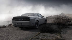灰色 Dodge Challenger 在暴風雨黃昏時停泊在懸崖邊。