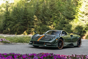 綠色Pagani Huayra跑車停泊在碎石路上，周圍有森林和紫色花朵。 — Surface Pro 壁紙