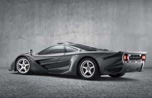 時尚啞光灰色McLaren F1超級跑車在攝影棚內，混凝土背景。 — MacBook Pro M3 壁紙