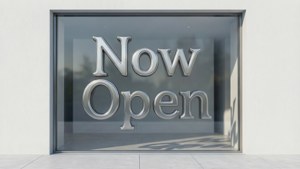 玻璃店面櫥窗，帶有大型銀色3D字母，顯示now open