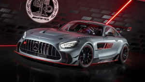 在黑暗工作室中，紅色燈光下的銀色AMG GT賽車，帶有紅色飾邊。 — 平治 AMG 壁紙