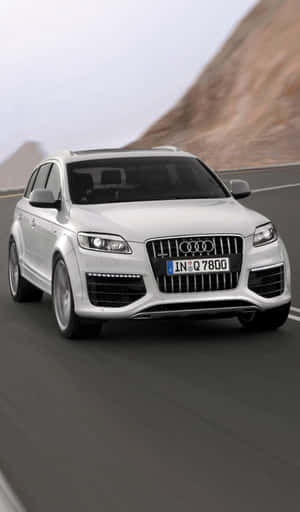 銀色Audi Q7 SUV在岩石地形的山路上快速行駛。 — Galaxy Tab A 壁紙