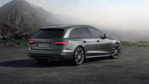 銀色 Audi RS4 Avant 旅行車停泊在山路上，背後是霧氣瀰漫的山峰。 — 奧迪 GIF 壁紙