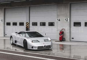 銀色Bugatti跑車停在帶有編號的車庫門前，路面潮濕。 — 布加迪 壁紙