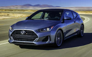 銀色Hyundai Veloster在日落時分於沙漠高速公路上飛馳。 — MacBook Pro M1 壁紙