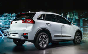 銀色Kia Niro SUV在舞台上展示，背後有霓虹城市天際線。 — Steam Deck OLED 壁紙