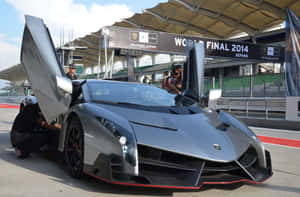 銀色林寶堅尼 Veneno 在賽道上打開車門，有工作人員和觀眾。 — MacBook Pro M4 壁紙