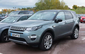 銀色 Land Rover Discovery SUV 停泊在停車場，背景有秋樹。 — Steam Deck OLED 壁紙