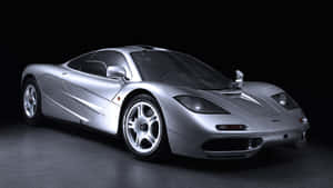 銀色McLaren F1超級跑車在攝影棚中，黑色背景和反射地板。 — 4K 法拉利 壁紙