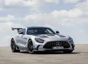 多雲天空下，露天瀝青地面上的銀色 Mercedes-AMG GT Black Series 跑車。 — 平治 AMG 壁紙
