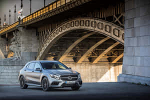 銀色 Mercedes-Benz SUV 停泊在歷史悠久的石橋和鐵橋下。 — MacBook Air 15 壁紙