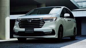 白色本田Odyssey Absolute小型貨車停泊在現代混凝土結構下。 — 本田 壁紙