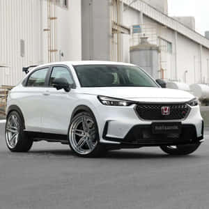 白色運動型SUV，配備定制輪胎，停在工廠建築附近。 — 本田 壁紙