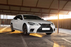 白色豪華轎車停在工業車庫中，沐浴在金色夕陽下。 — Surface Pro 壁紙