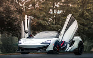 白色McLaren跑車，打開鷗翼車門，停在林蔭大道上。 — Steam Deck OLED 壁紙