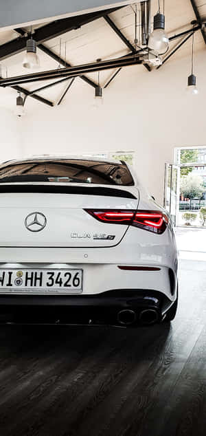 白色 Mercedes-AMG CLA 45 S 在現代車庫中，深色木地板和吊燈。 — Nubia Neo 5 壁紙