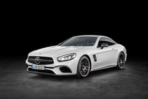 白色 Mercedes-AMG SL63 跑車，配備黑色輪圈和紅色制動卡鉗，位於暗色工作室地板。 — Surface Laptop 壁紙