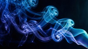 藍色煙霧漩渦在黑色背景上以流暢的抽象圖案流動。