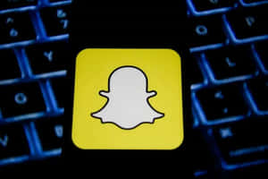 Snapchat標誌顯示喺一個有藍色背光燈嘅深色鍵盤上。